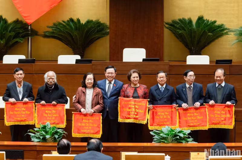NA Chairman Vuong Dinh Hue (fourth, left) presents longevity greeting flags to over-70-year-old former NA leaders, officials and deputies. (Photo: NDO)