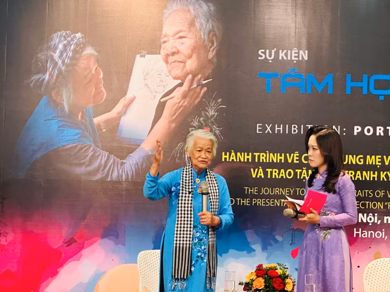 Painter Dang Ai Viet (L) at the event.
