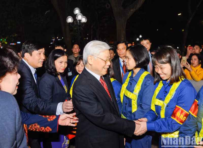 Party General Secretary Nguyen Phu Trong visits and chats with workers of the Hanoi Green Park Company who are working on New Year's Eve.