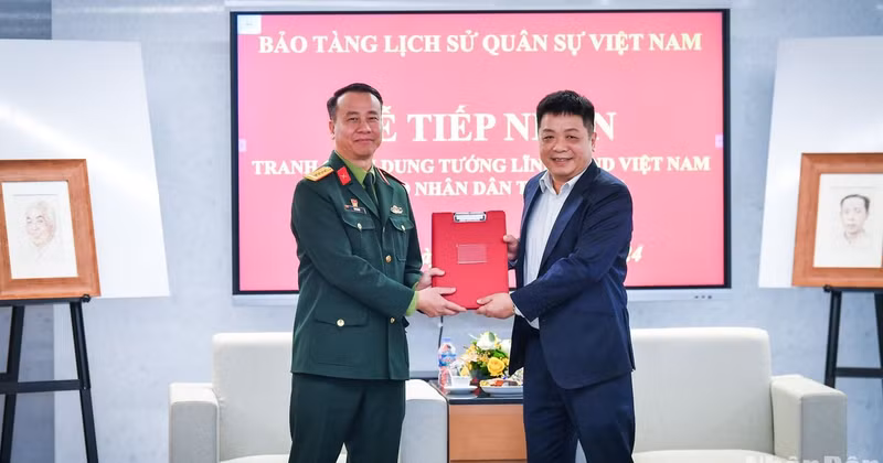 Que Dinh Nguyen, Deputy Editor-in-Chief of Nhan Dan Newspaper, and Colonel Le Vu Huy, Director of the Vietnam Military History Museum, handed over the document for accepting the collection of paintings featuring renowned generals.
