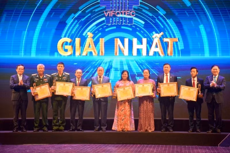 Deputy PM Tran Luu Quang and Dr. Phan Xuan Dung present the first prizes to outstanding authors and groups of authors.