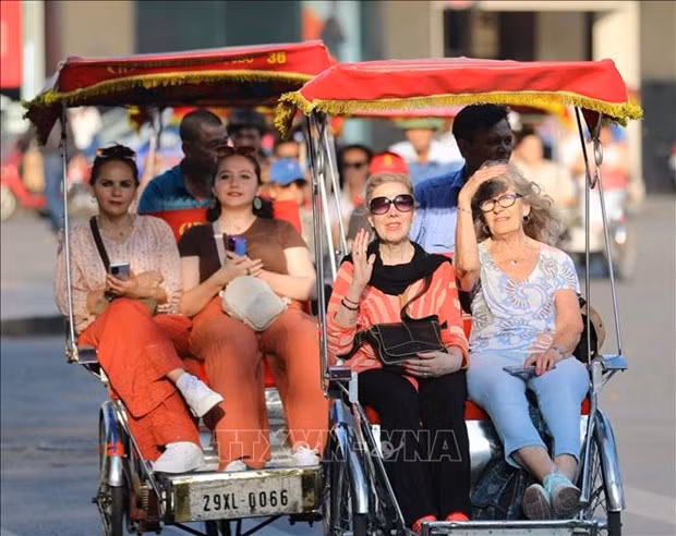 Foreign tourists on cyclos touring the Old Quarter, Hoan Kiem Lake, downtown Hanoi. (Photo: VNA)