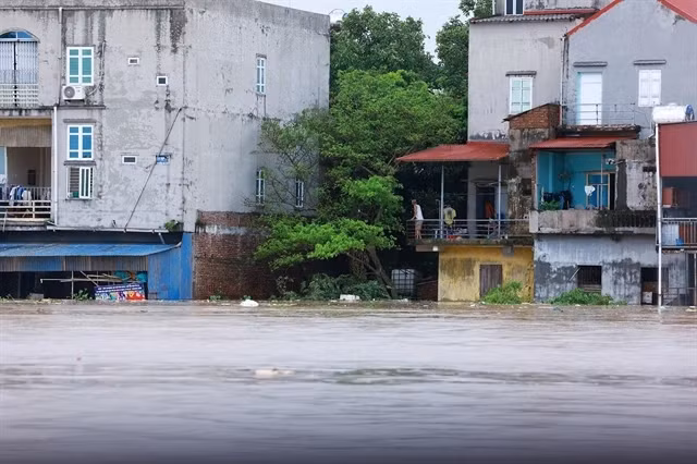 Houses in Van Ha commune are submerged by floodwaters as the river continues to overflow (Photo: VNA)