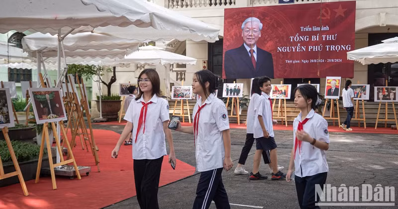 Teachers and students from Hoan Kiem Secondary School visit the photo exhibition.