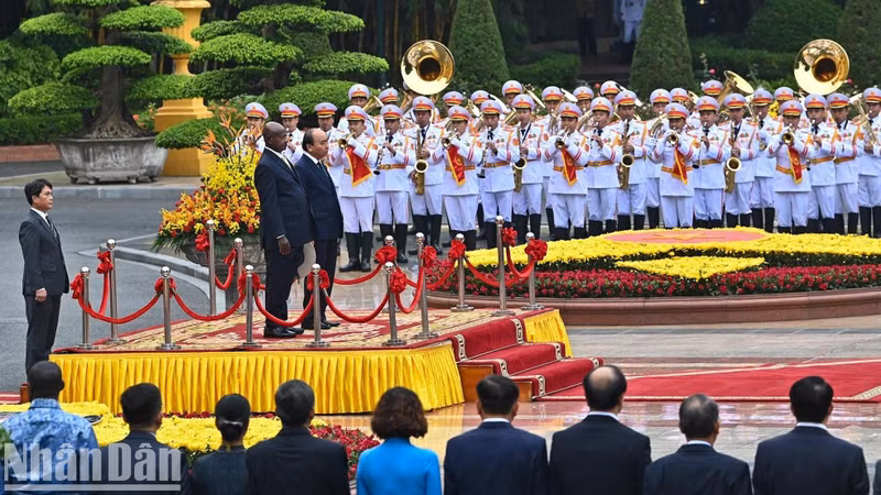 President Nguyen Xuan Phuc and his Ugandan counterpart Yoweri Kaguta Museveni stand on the podium listen to the playing of the two countries’ national anthems.