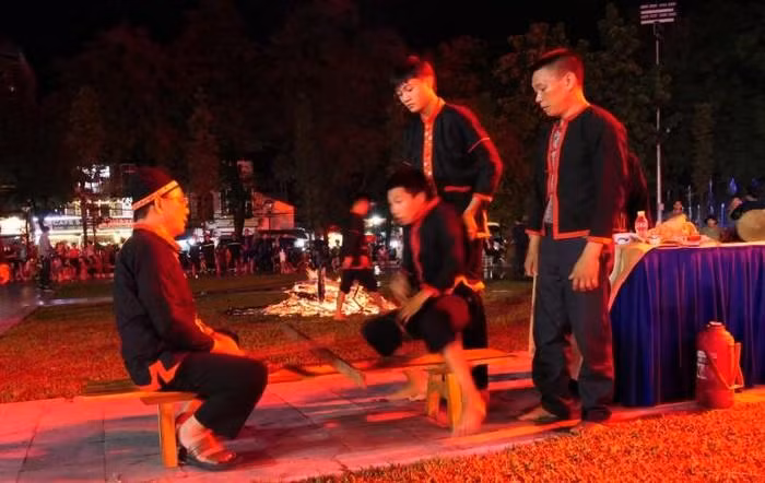 After nearly one hour of performing the ritual, Pa Then men sit opposite the shaman to prepare for the dance.