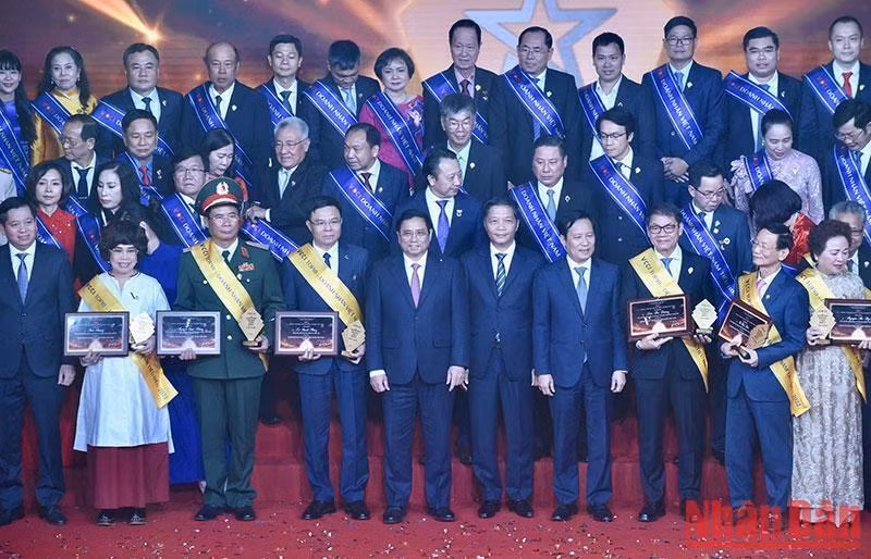 PM Pham Minh Chinh (5th from left, first row) and outstanding businesspeople pose for a group photo. (Source: NDO)