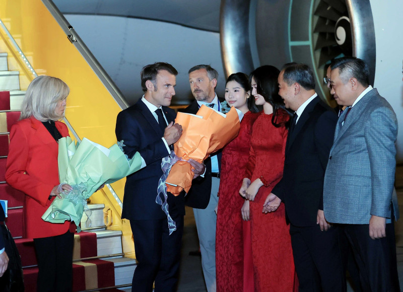 French President Emmanuel Macron and his spouse Brigitte Macron are welcomed at Noi Bai International Airport in Ha Noi on May 25 evening. (Photo: VNA)