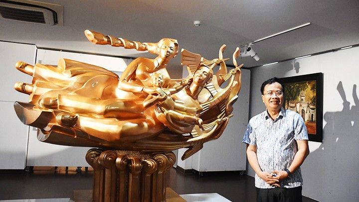 Painter and sculptor Dinh Gia Thang beside his sculpture “Roots of Happiness.”