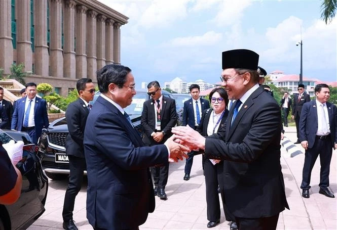 Malaysian PM Anwar Ibrahim (right) welcomes Vietnamese PM Pham Minh Chinh in Kuala Lumpur on May 25 afternoon. (Photo: VNA) 