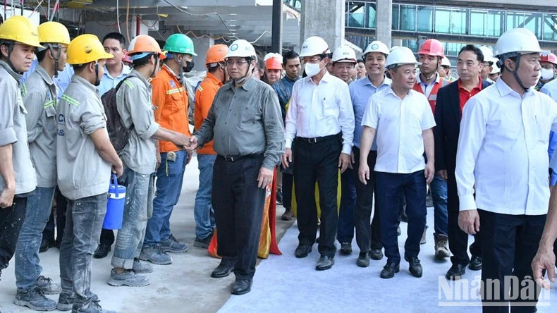 Prime Minister Pham Minh Chinh (second from the right) extends New Year greetings to workers at the construction site of the Terminal 3 project at Tan Son Nhat International Airport in Ho Chi Minh City. (Photo: NDO)