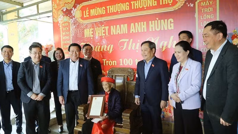 Politburo Member Nguyen Xuan Thang presents a congratulatory card from the President of Vietnam to Heroic Vietnamese Mother Hoang Thi Nghi on the occasion of her 100th birthday.