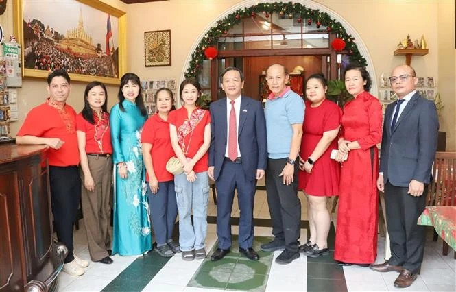 From right: Ambassador Nguyen Minh Tam (5th from right) and the family of Le Dung, former president of the Vietnamese Association in Vientiane. (Photo: VNA) 