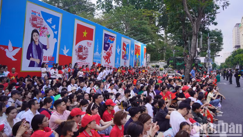 Many families, groups of young people, and elderly citizens gather along Dong Khoi and Le Duan streets, selecting the best spots to observe the parade.