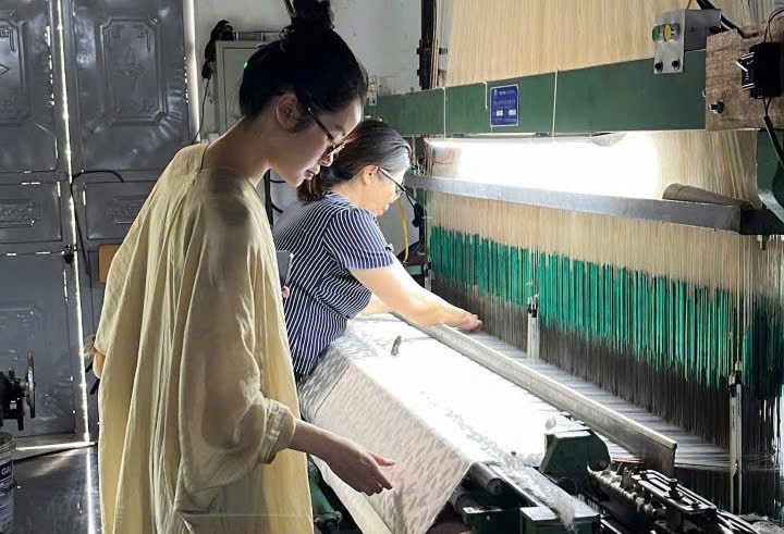 Tran Minh Nhi, founder of Du Nhien, carefully studies every stage of the silk weaving process to select the finest products.