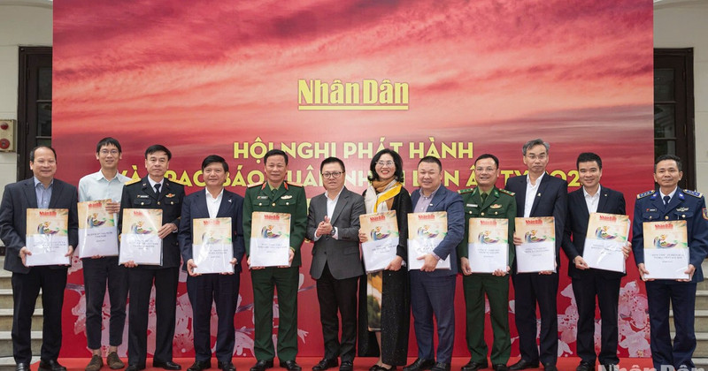 Editor in Chief of Nhan Dan Newspaper Le Quoc Minh, along with other delegates, presents Tet newspapers to representatives of the recipients. 
