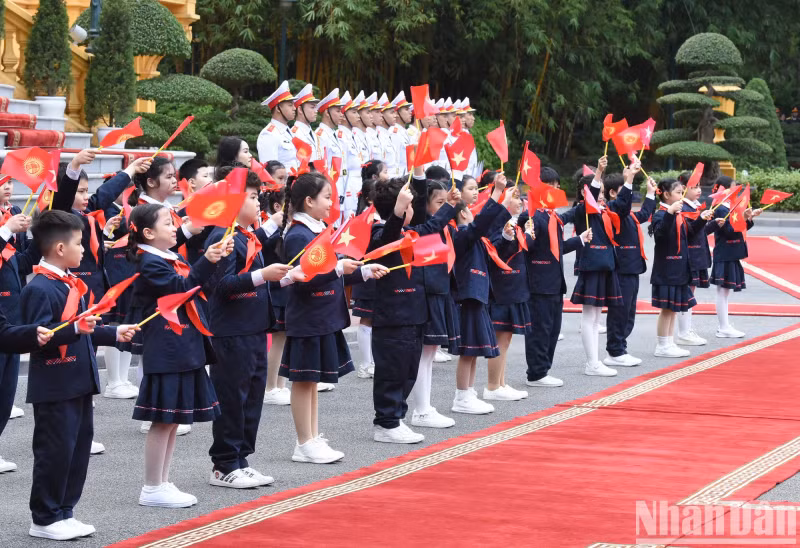 The children wave to the two Prime Ministers.