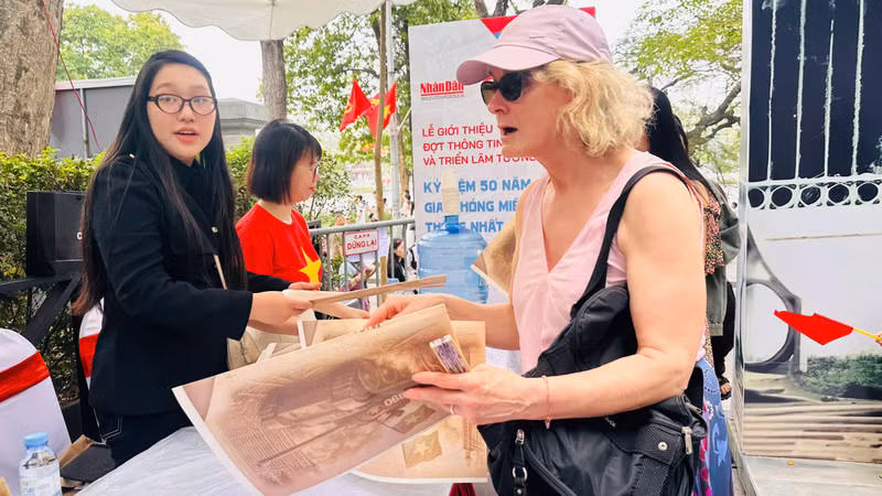 Lucia (from Ireland) receives Nhan Dan Newspaper's special supplement.