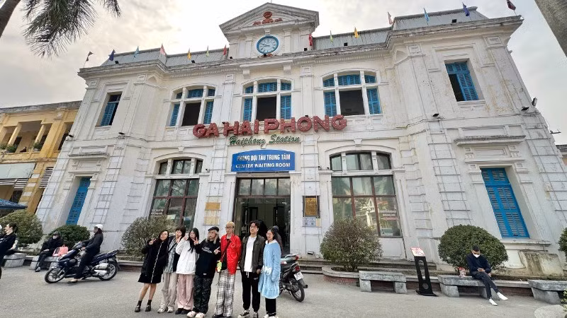 Visitors pose for photos in front of Hai Phong Railway Station.