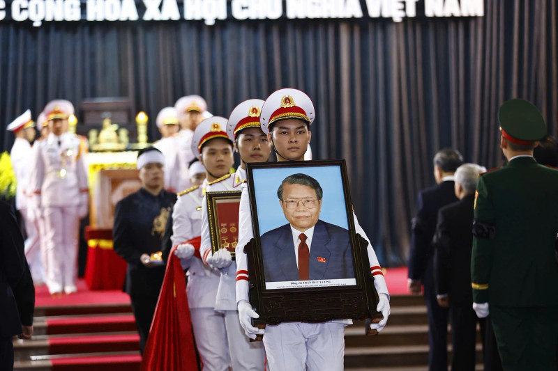 The portrait and coffin of former State President Tran Duc Luong are transferred to the hearse following the memorial service at the National Funeral Hall in Ha Noi on May 25 morning. (Photo: VNA)