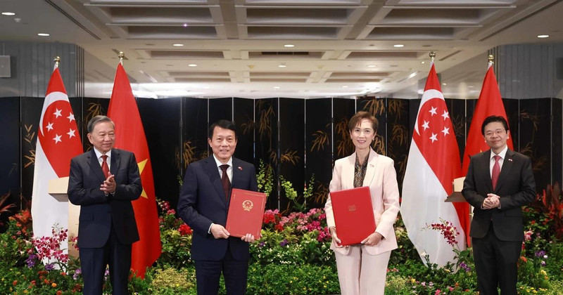 Party General Secretary To Lam (L) and Singaporean PM Lawrence Wong (R) witness the exchange of a MoU on digital transformation between the Vietnamese Ministry of Public Security and the Singaporean Ministry of Digital Development and Information on March 12. (Photo: VNA) 