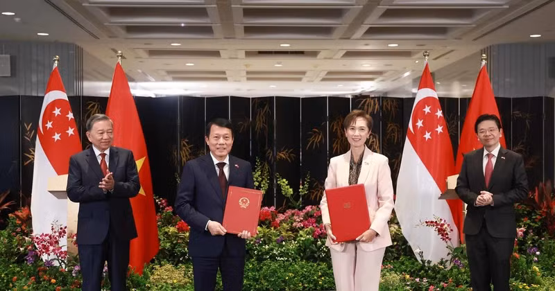 Party General Secretary To Lam (L) and Singaporean PM Lawrence Wong (R) witness the exchange of a MoU on digital transformation between the Vietnamese Ministry of Public Security and the Singaporean Ministry of Digital Development and Information on March 12. (Photo: VNA) 