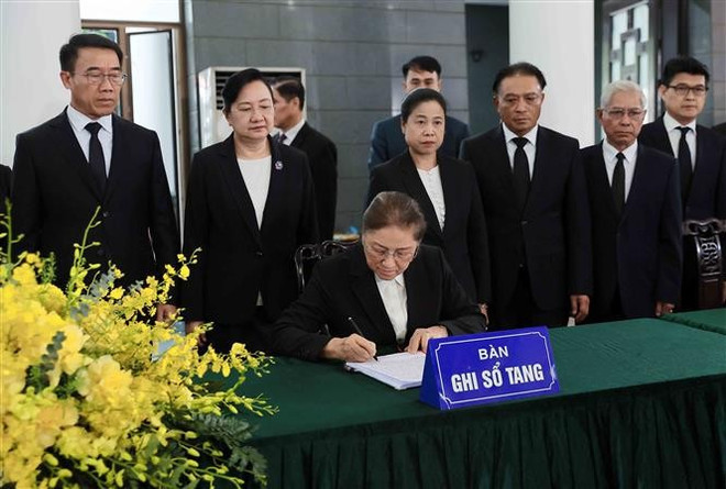 Lao Vice President Pany Yathotou writes in the condolence book for former State President Tran Duc Luong. (Photo: VNA)