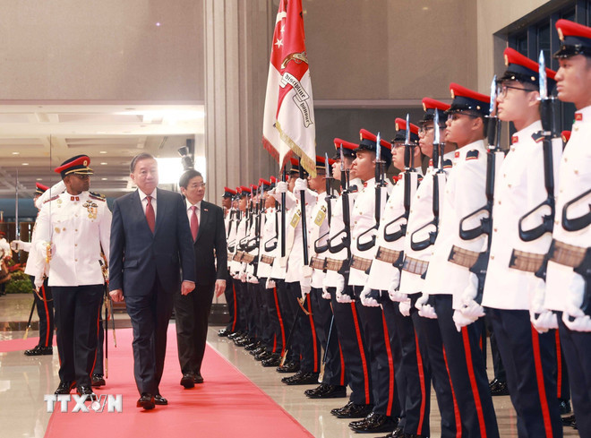 General Secretary of the Communist Party of Vietnam (CPV) Central Committee To Lam (R) and Singaporean Prime Minister and Secretary-General of the ruling People's Action Party (PAP) Lawrence Wong review the Guard of Honour of Singapore at the welcome ceremony on March 12. (Photo: VNA) 