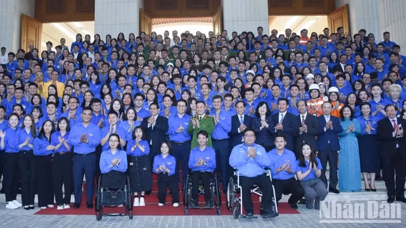Prime Minister Pham Minh Chinh and officials pose for a group photo with young people at the dialogue on March 24. (Photo: NDO)