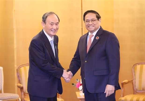 Prime Minister Pham Minh Chinh (R) and former Japanese Prime Minister Suga Yoshihide. (Photo: VNA)