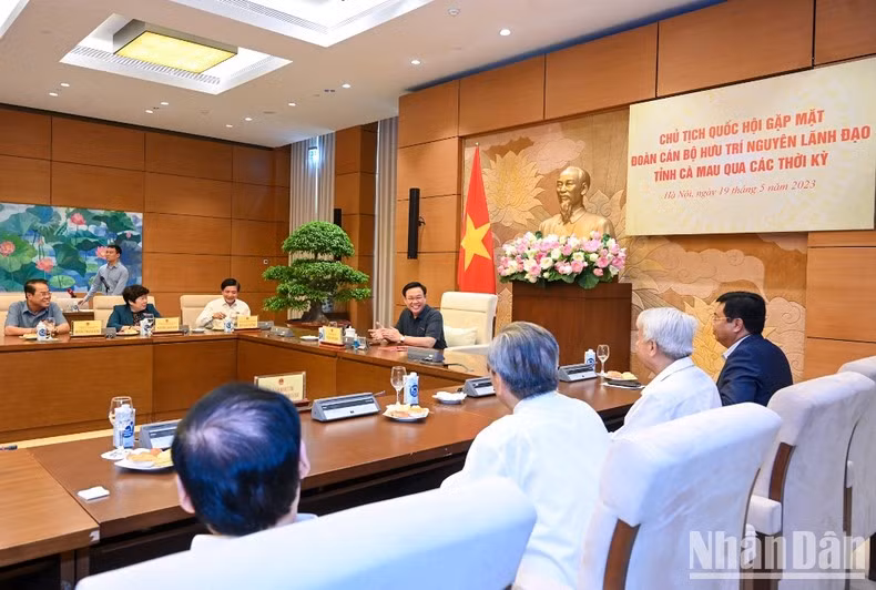 Na Chairman Vuong Dinh Hue talks with the delegates attending the meeting.