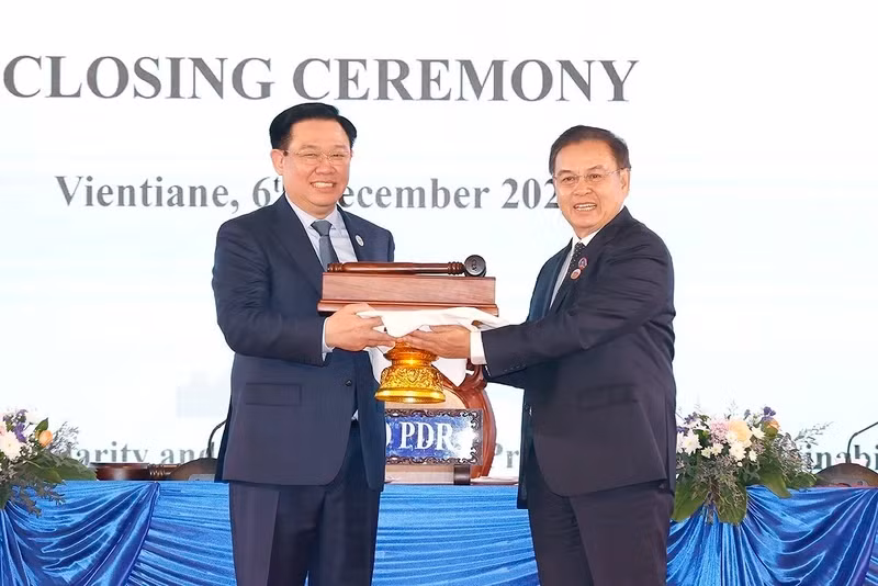 NA Chairman Vuong Dinh Hue receives the hammer from Lao NA Chairman Saysome Phomvihane to host the second summit in 2025. (Photo: VNA)