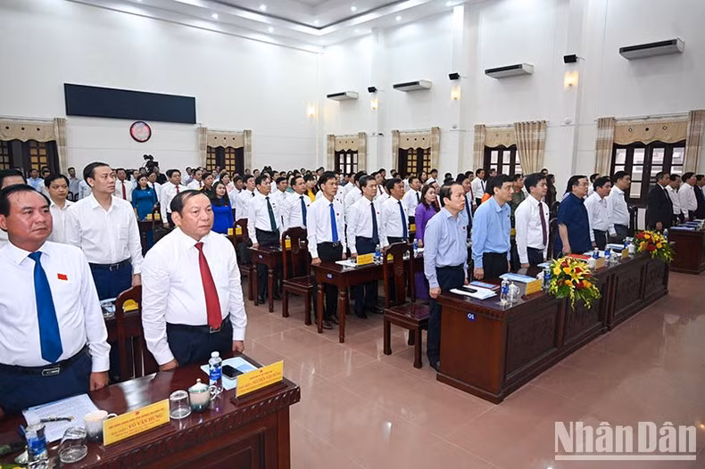 NA Chairman Vuong Dinh Hue and other delegatesperform the flag-saluting ceremony at the opening of the session.