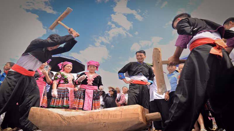 People take turns pounding the sticky rice continuously while it's still hot, to ensure smoothness and elasticity.