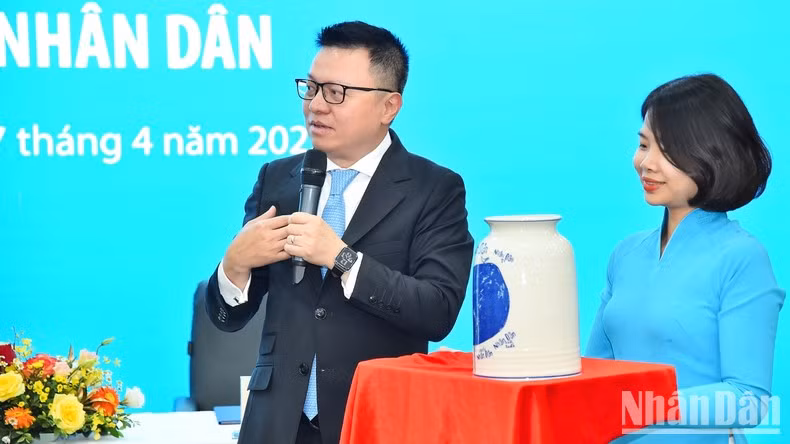 Nhan Dan Newspaper’s Editor-in-chief Le Quoc Minh introduces the unique features of the souvenir to the leaders of Vietnam Airlines.