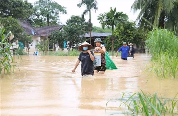 Residents in Yen Hop commune, Quy Hop district, Nghe An province move their property and furniture from flooded houses to safer places (Photo: VNA)