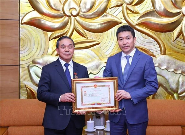 VUFO President Phan Anh Son (R) presents the insignia to Lao Ambassador to Vietnam Sengphet Houngboungnuang (Photo: VNA)