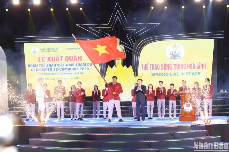 Head of the Vietnamese sports delegation Dang Ha Viet receives the flag from the Deputy Prime Minister.