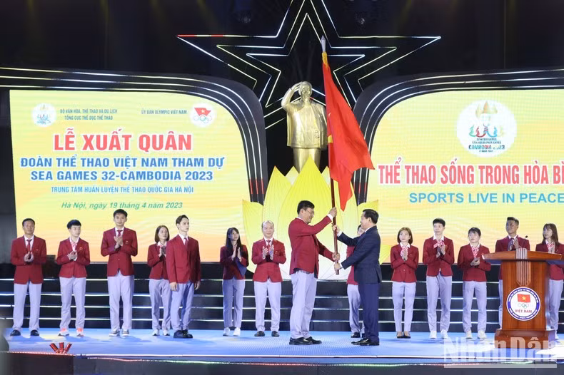 Deputy Prime Minister Le Minh Khai hands over the flag to Head of the Vietnamese sports delegation Dang Ha Viet.