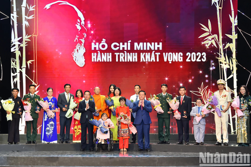 President Vo Van Thuong and Head of the PCC’s Communications and Education Nguyen Trong Nghia present flowers and symbols to outstanding examples at the programme.