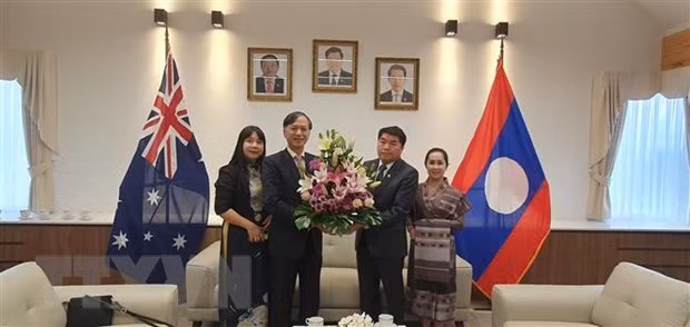 Vietnamese Ambassador to Australia Nguyen Tat Thanh (second, left) congratulates his Lao counterpart on the Bunpimay festival. (Photo: VNA) 