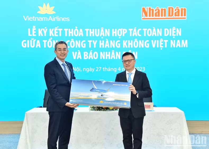 Chairman of the Board of Management of Vietnam Airlines Dang Ngoc Hoa presents a souvenir to Nhan Dan Newspaper’s Editor-in-chief Le Quoc Minh.