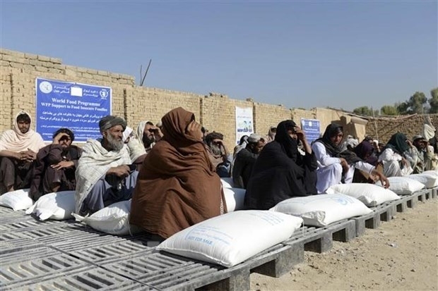 Afghans receive food aid from the World Food Programme in Kandahar. (Photo: AFP/VNA)