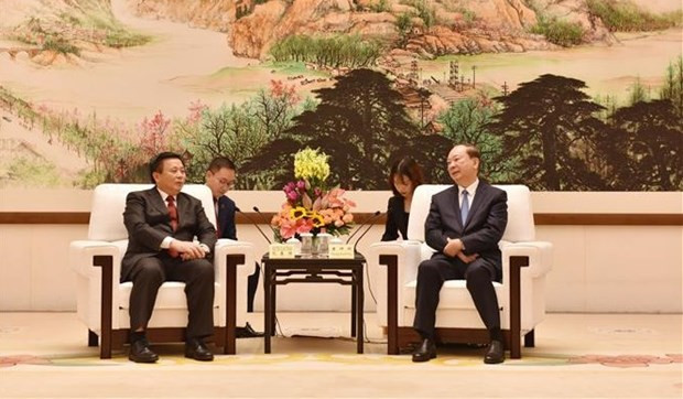 Politburo member Nguyen Xuan Thang (L) meets with Politburo member Huang Kunming. (Photo: VNA) 