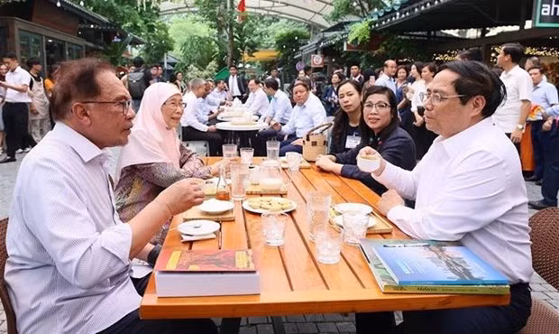 Vietnamese Prime Minister Pham Minh Chinh, his visiting Malaysian counterpart Anwar Ibrahim and their spouses enjoyed coffee at the outdoor reading space on Hanoi's book street. (Photo: VNA)