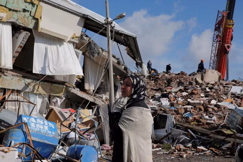 A woman stands in front of a ruined building after an earthquake in Gaziantep, Turkey. (Photo: REUTERS)