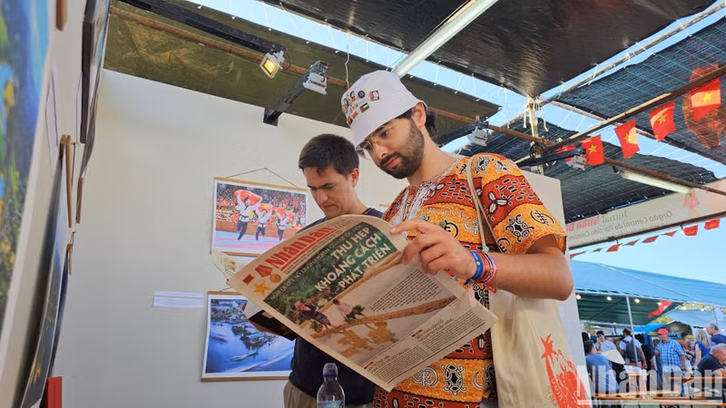 Two Portuguese students Jose Flores and Vitor Arauj are impressed with the publications of Nhan Dan Newspaper.