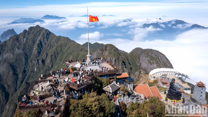 The clouds flow like streams and waterfalls, revealing the majestic and beautiful Fansipan peak amidst the high blue sky and a magical sea of clouds like a fairyland of Buddha's land.