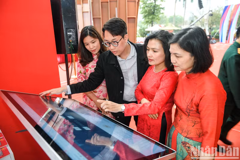 The delegates and visitors visit the booth of Nhan Dan Newspaper.