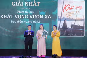 Director Hoang Ha Le (C) receives the first prize at the award ceremony 